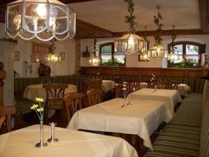 ein Restaurant mit 4 Tischen und weißem Tischtuch in der Unterkunft Landhotel Zahn's Weißes Rössle - ruhig schlafen- gut frühstücken - lecker essen in Dietmannsried