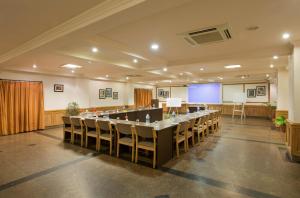 una gran sala de conferencias con una mesa larga y sillas en The Manor Kashipur by Leisure Hotels, en Kāshīpur
