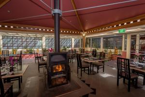 a restaurant with a fireplace in the middle of the room at La Maison Boutique Hotel in Katoomba