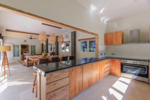 uma cozinha com armários de madeira e uma sala de estar em Villa La Luvier em Canggu