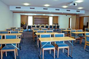 a room with tables and chairs and a classroom at IMPIQ Hotel in Trnava