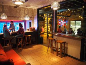 un gruppo di persone seduti al bar in un ristorante di Kimberley Travellers Lodge - Broome YHA a Broome