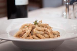 a white bowl of pasta on a table at B&B Le Caselle "Il Baraccotto" in Lucignano