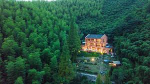 a large house in the middle of a forest at Arcadia Resorts in Deqing