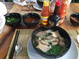 a table with a bowl of food on a plate at Enkosa 4-Bedroom Wooden Luxury House in Siem Reap