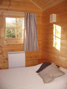 a bedroom with a bed in a wooden room at La Simonette in Dienville