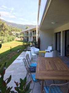 een patio met een houten tafel en stoelen bij Appartement Duplex Proche Mer in Rayol-Canadel-sur-Mer