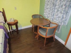 a room with a table and chairs and a bed at Travel Eagle Inn Motel in Long Beach
