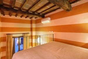 a bedroom with orange and white striped walls and a bed at Apartments Puccini in Florence