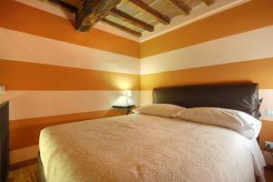 a bedroom with a bed with orange and white stripes at Apartments Puccini in Florence