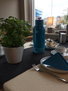 une table avec une bouteille bleue, une plaque et une plante dans l'établissement Haus Meeresgruß, à Cuxhaven