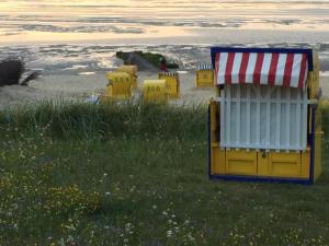 um grupo de estruturas de jogo amarelo em uma praia em Haus Meeresgruß em Cuxhaven