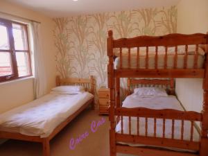 a bedroom with two bunk beds and a window at Cairngorm Highland Bungalows in Aviemore