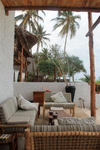 a patio with couches and a table and palm trees at Villa Marisella in Kiwengwa