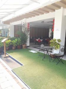 un patio con mesa, sillas y plantas en Aya Place en Pattaya South