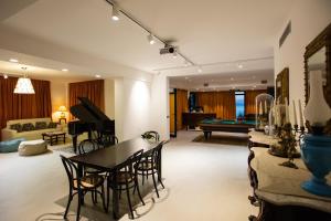 ein Wohnzimmer mit einem Klavier, einem Tisch und Stühlen in der Unterkunft Villa Solaria in Massa Lubrense
