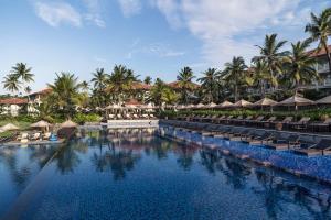 a pool at a resort with chairs and umbrellas at Anantara Peace Haven Tangalle Resort in Tangalle