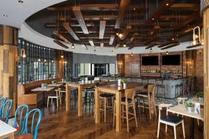 a restaurant with wooden tables and chairs and a bar at Copthorne Lakeview Executive Apartments Dubai, Green Community in Dubai