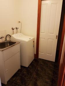 a small kitchen with a sink and a refrigerator at King Street Apartments in Warrnambool