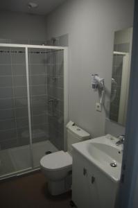 a bathroom with a toilet and a shower and a sink at Hotel de Bordeaux in Gramat