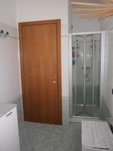baño con puerta de madera y ducha en Al Cappellino, en Sona