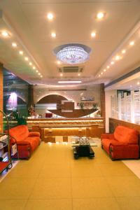 a lobby with orange couches and a stage at Taj Inn Hotel in Agra