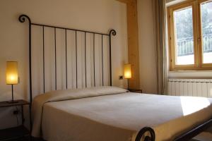 een slaapkamer met een groot bed met 2 lampen bij Agriturismo La Cascina di Opaco in Norcia