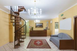 - un salon avec un escalier en colimaçon et un canapé dans l'établissement Hotel Bellavista, à Maierà