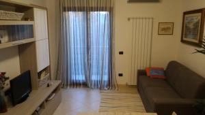 Appartamento Berlicche في Agliana: غرفة معيشة مع أريكة ونافذة كبيرة