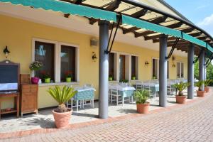 un patio con mesas y sillas bajo una pérgola en Locanda Grego, en Bolzano Vicentino