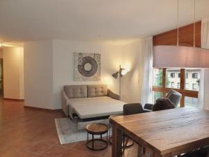 een woonkamer met een bank en een tafel bij La Planüra 11 in Maloja