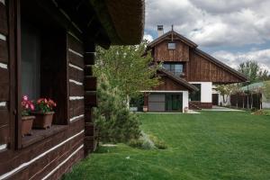 una casa con un patio de césped al lado de un edificio en Gosteria Hata PODOPRYGORA, en Obukhivka