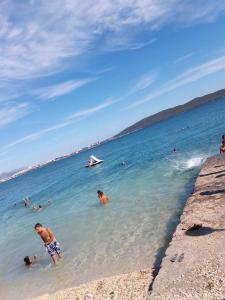 a group of people in the water at a beach at Apartments Pavlinović in Kaštela
