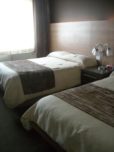 a hotel room with two beds and a window at Complexe Hotelier Le 55 in Bécancour