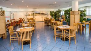 - un restaurant avec des tables et des chaises en bois dans une chambre dans l'établissement Hotel Express Aosta East, à Aoste