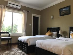 um quarto de hotel com duas camas e uma janela em Butsugen em Catmandu
