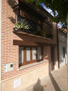 un edificio de ladrillo con un balcón con flores. en Casa Rural Isabel en Villaflores