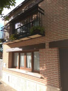Edificio de ladrillo con 2 ventanas y balcón en Casa Rural Isabel en Villaflores