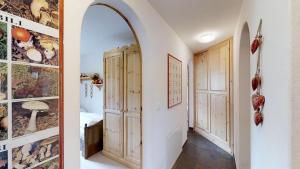 un couloir avec une arche et une pièce avec des portes en bois dans l'établissement Pinellas, à Celerina