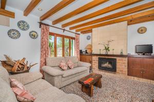 ein Wohnzimmer mit Couch und Kamin in der Unterkunft Can Boi in Pollença