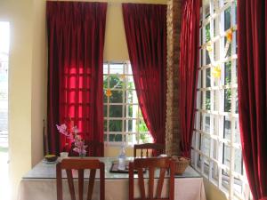 a dining room with red curtains and a table and two chairs at KOL House in Phnom Penh +65 photos