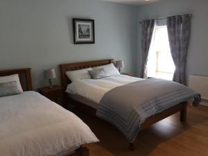 a bedroom with two beds and a window at Cornerstone 2 Bed Townhouse in Charlestown