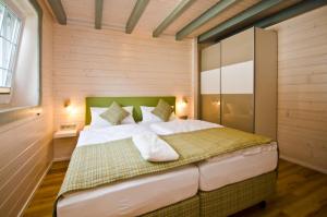 - une chambre avec un lit dans une pièce dotée de murs en bois dans l'établissement Ferienblockhaus Auerhahn & Luchs, à Hahnenklee