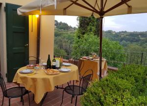 a table and chairs on a patio with an umbrella at Azienda Agricola Le Querce in Palaia