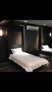 a bedroom with a large white bed and a mirror at Miracle Suite in Ipoh