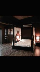 a bedroom with a canopy bed with two lamps at Miracle Suite in Ipoh