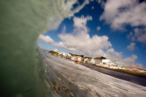 a person riding a wave on a surfboard in the ocean at Aparthotel Barracuda in Ponta Delgada