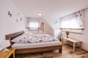 Schlafzimmer mit einem Bett, einem Tisch und Fenstern in der Unterkunft Ferienhaus Stark in Eisenach
