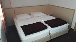 a small bed with two pillows on top of it at Rooms K in Maribor