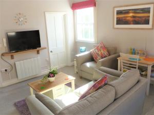 uma sala de estar com 2 sofás e uma televisão de ecrã plano em Chalice Lodge em Glastonbury